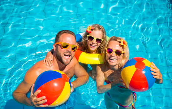 Family playing in a pool with beach balls