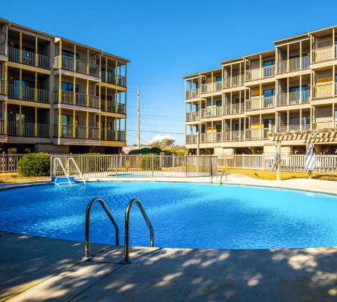 The Island Beach and Racquet Club pool in the foreground with condos in the background