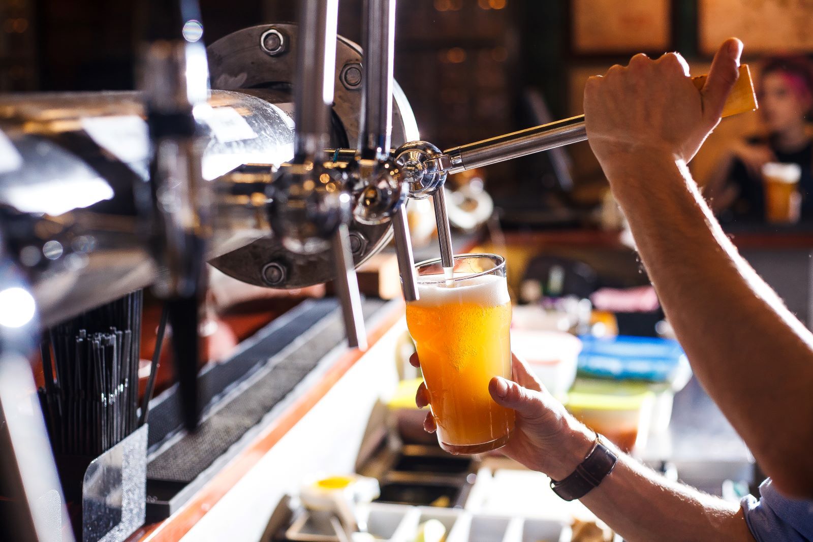 Bartender pouring a beer from tap at Atlantic Beach brewery