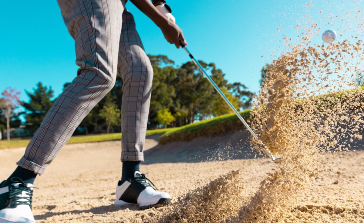 Man hitting golf ball from sand trap