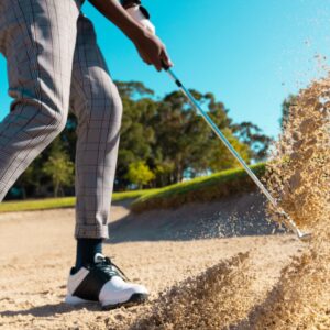 Man hitting golf ball from sand trap